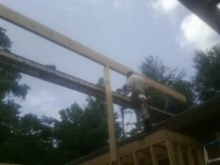 Carpenter setting a ridge beam over a new addition frame — Ice Dam Removal by Roofing Brothers in Grenloch