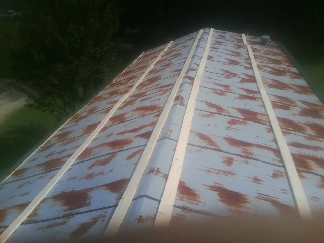 Rusted metal roof panels with new wood purlins before replacement — Storm Damage Roof Repair in Grenloch by Roofing Brothers