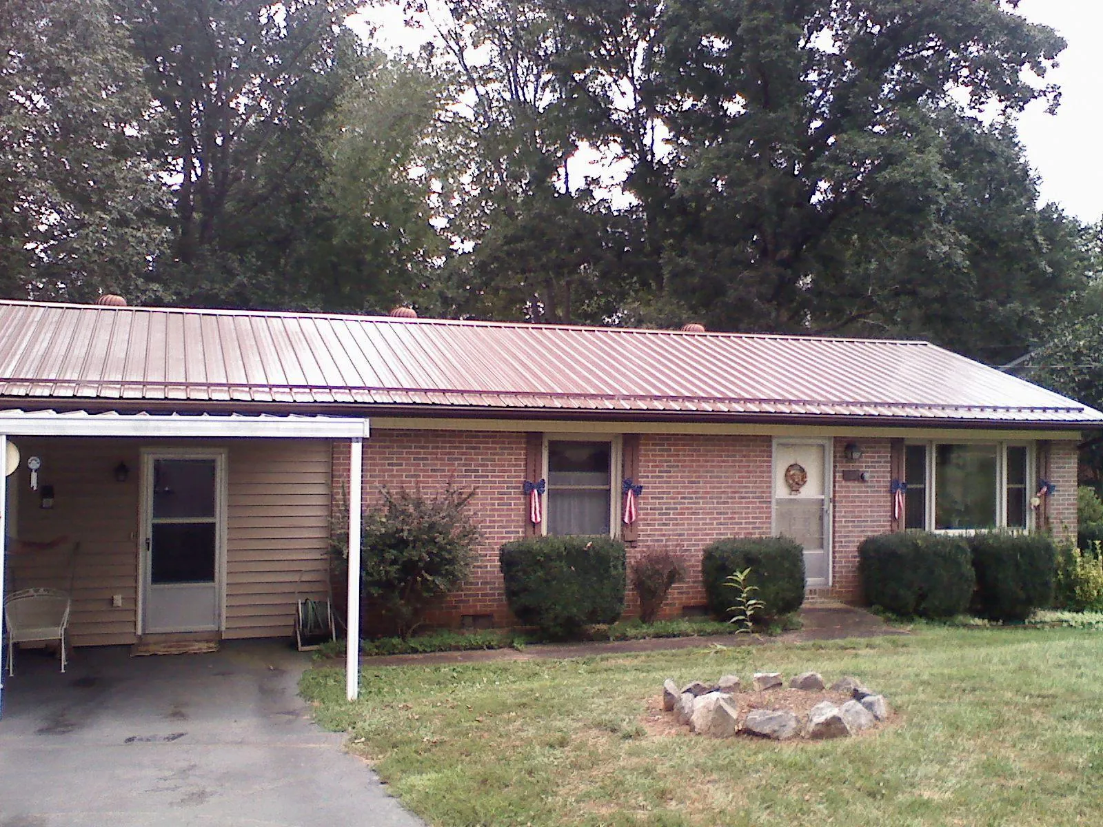 Bronze metal roof and carport on a brick ranch home — Roof Repair work by our crew in Grenloch